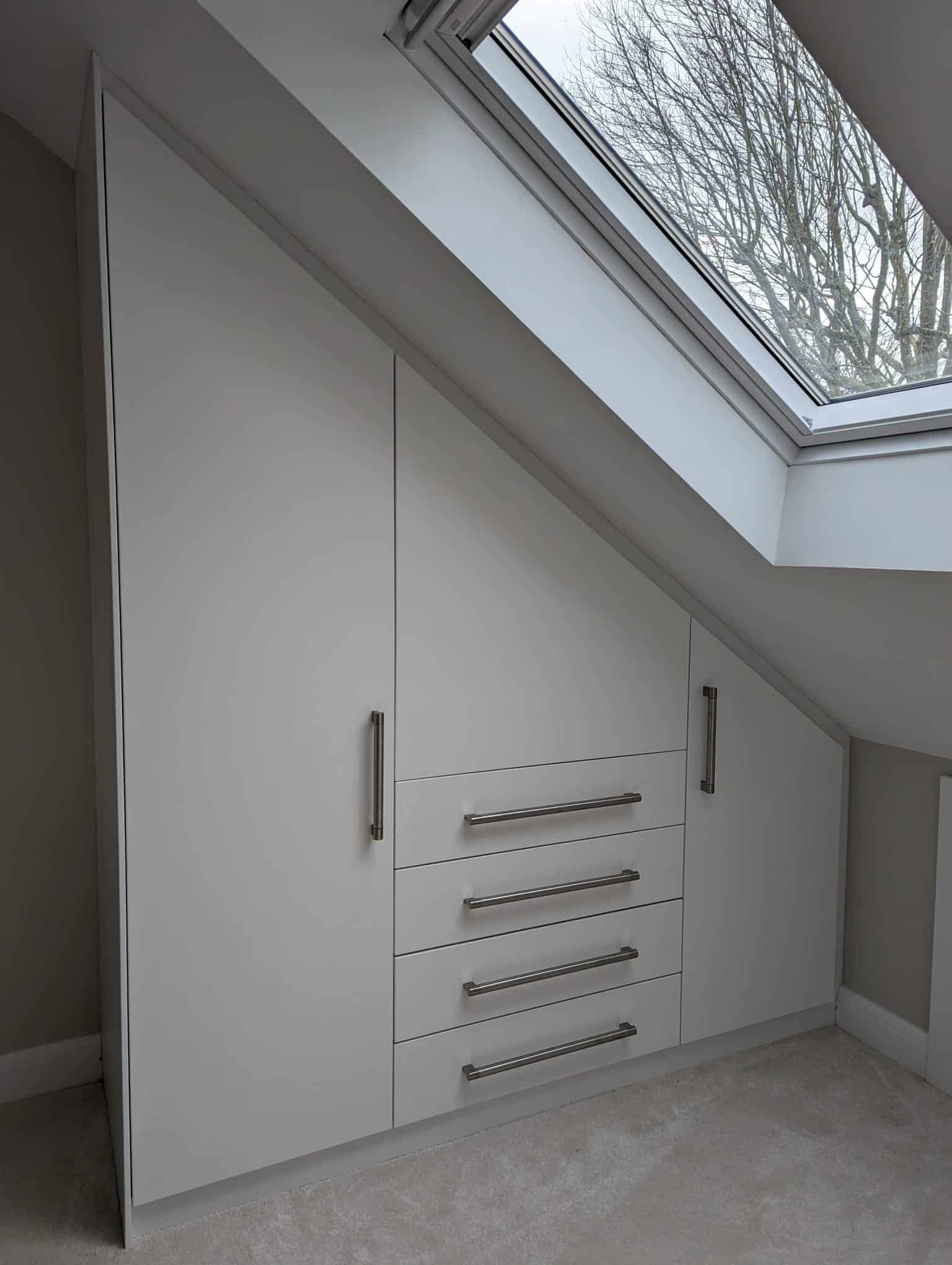 Storage wardrobe built into slanted roof